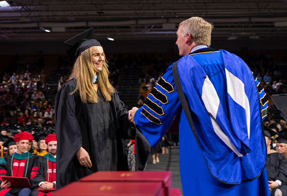 President Weinman and graduate student at Friday's Commencement.